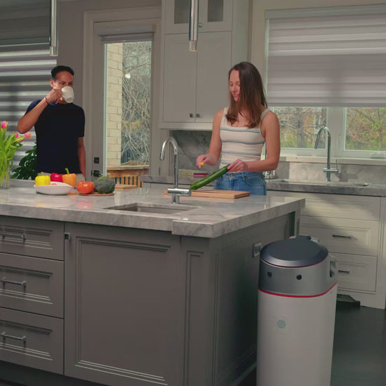 Husband and Wife putting Food Scraps to Get Real Compost with the LILA Home Electric Indoor Composter