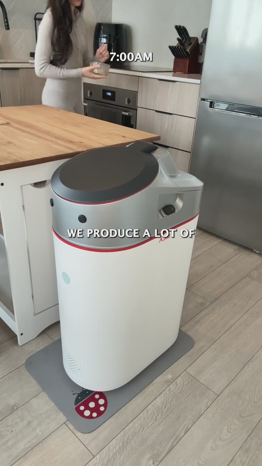 Woman turning food scraps into Category A compost with the LILA Home Electric Indoor Composter